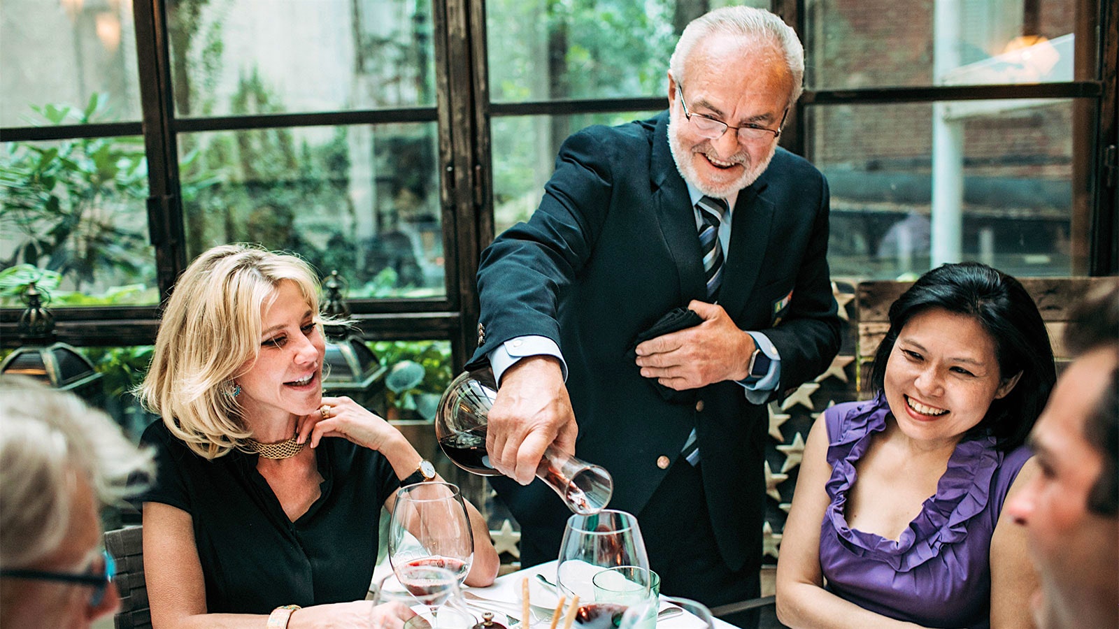 Wine director Renzo Rapacioli pours a bottle for two of Sistina’s guests